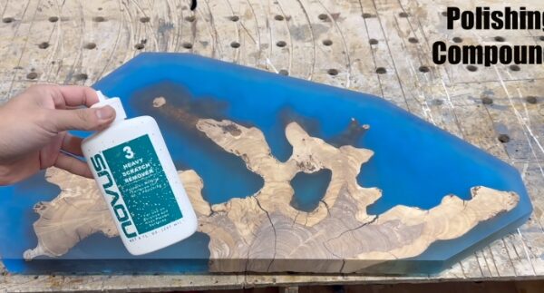 polishing a blue coral leaf made with deep pour epoxy resin and olivewood
